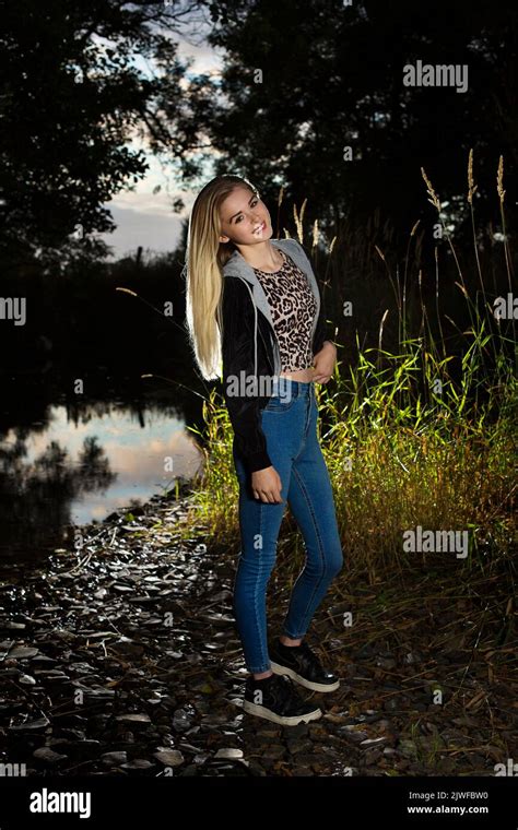 A Blonde Teenager Wearing Jeans Outdoors By A Riverbank Stock Photo Alamy