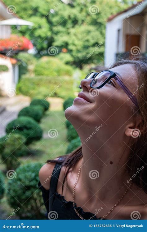Close Up Portrait Of Beutiful Brunette Girl In Glasses That Lookes Up Green Patio On The