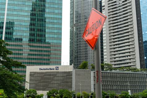 Tanda Hatihati Di Samping Tanda Deutsche Bank Di Gedung Kantor Foto