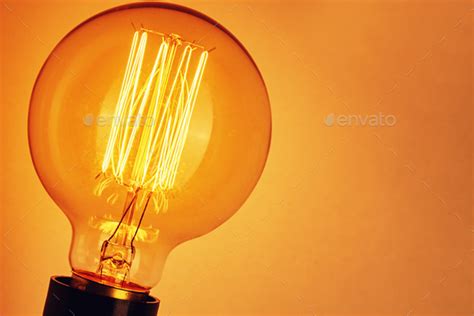 Vintage Light Bulb On Yellow Background Closeup Glowing Edison Bulb