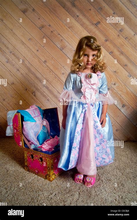 Proud But Serious A Three Year Old Blonde Girl Shows Off Fancy Clothes From Her Treasure Chest