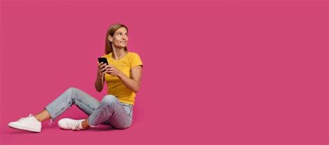 Premium Photo Happy Adult Caucasian Woman Blonde In Casual Typing On Smartphone Sits And Looks