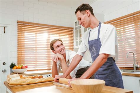 Happy Caucasian Gay Couple Cooking Together In The Kitchen While