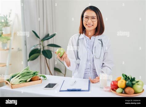 Portrait Of Young Smiling Female Nutritionist In The Consultation Room