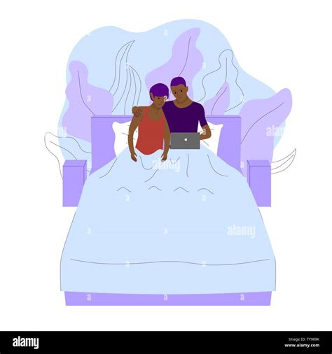 Gay Black Couple Is Laying Under Blanket On A Bed And Watching Movie On