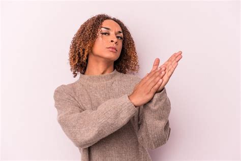 Joven mujer transexual latina aislada de fondo rosa sintiéndose enérgica y cómoda frotándose