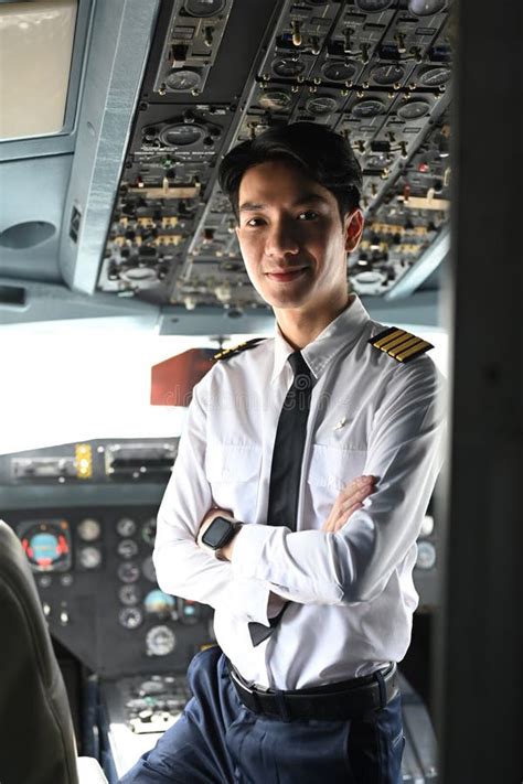 Portrait Of Confident Pilot Is Smiling And Posing In The Cockpit Of An