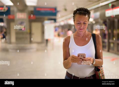 Mature Beautiful Tourist Woman Using Phone At Subway Station Stock