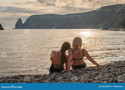 Two Beautiful Lgbt Lesbian Female Friends Relax And Happy At The Beach Sitting On The Sand