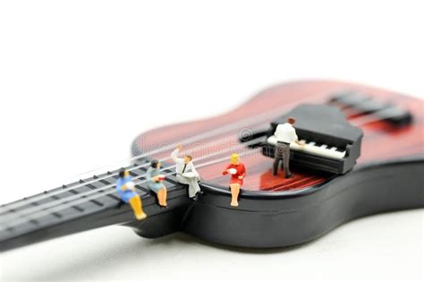 Miniature People Man Play Mini Piano With Sitting On Acoustic Guitar