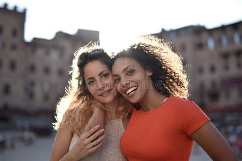 Blonde And Black Haired Lady Hugging Each Other Behind The Buildings Stock Image Image Of