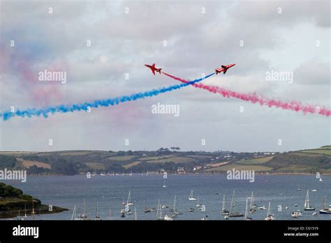 Two Red Arrows jets crossing over in an air display above Falmouth, Cornwall UK Stock Photo - Alamy