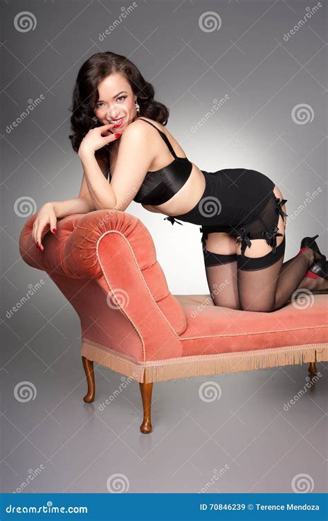 Cute Retro Pinup In Black Lingerie On Vintage Chaise Stock Image