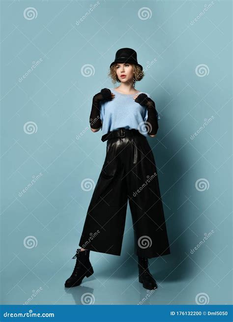 Junge Hübsche Blonde Gelockte Frau Im Eleganten Schwarzen Leder Kleidungshut Und Massiven in Den