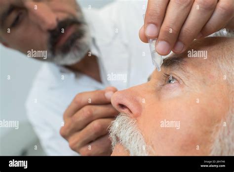 Poniendo gotas para los ojos fotografías e imágenes de alta resolución