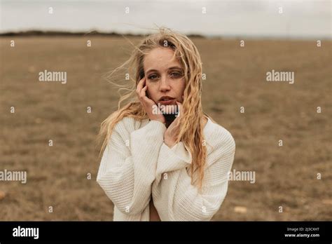 Charming Blonde Female With Freckles Looking At Camera Standing
