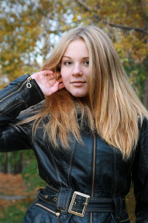 Fille Une Blonde Naturelle Avec De Longs Cheveux Dans Une Veste Noire Redresse Ses Cheveux Photo
