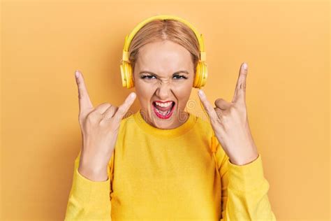 Jeune Femme Blonde écoutant De La Musique à L aide D écouteurs Criant Avec Une Expression Folle