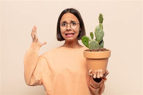Joven latina gritando con las manos en alto sintiéndose furiosa frustrada estresada y molesta