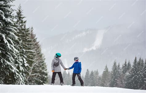 Premium Photo Young Man And Woman Snowboarder Standing On High Snow