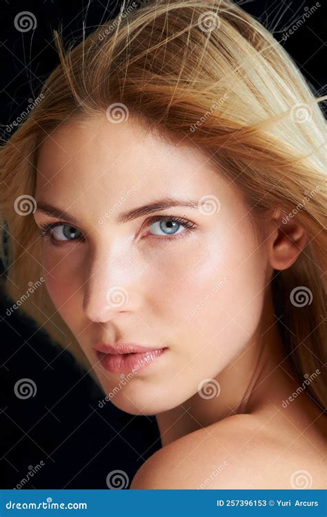 Simple Une Femme Blonde Posant Devant Un Fond Noir Tandis Que Le Vent Souffle Dans Ses Cheveux