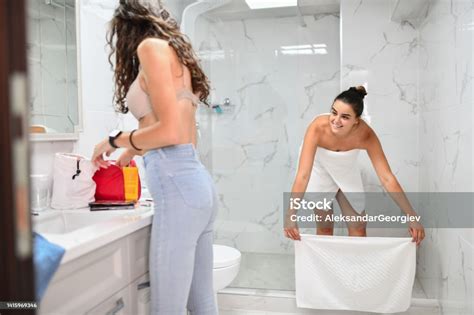 Female Spreading Towel To Step On It After Shower While Girlfriend Prepares Make Up For Night