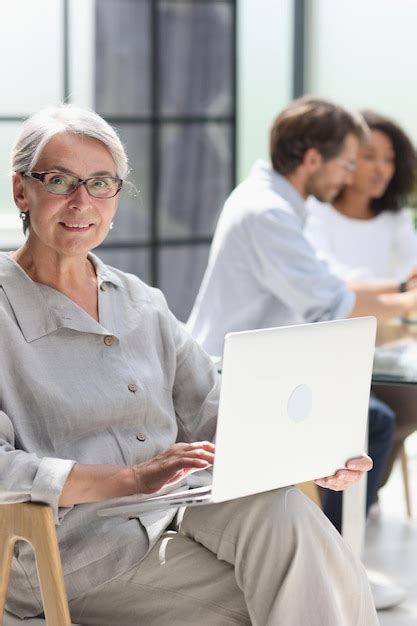 Premium Photo Mature Woman Sitting With Laptop Looking At Camera