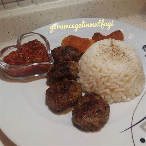 A Plate With Rice Meatballs And Sauce On It