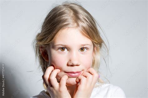 Portrait D Une Enfant Fille Blonde Avec Ses Mains Au Visage Adobe Stock