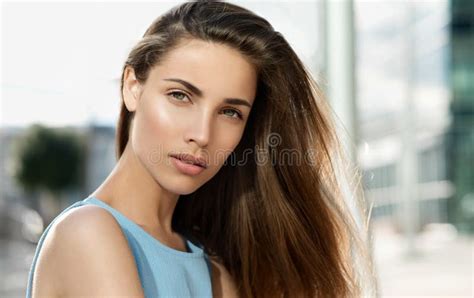 Beauty Smiling Model With Natural Nude Make Up And Long Eyelashes Holding Lipstick Stock Photo