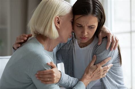 Caring Mature Mother Comforting Hugging Upset Adult Daughter Close Up