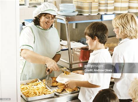 Students Being Served Lunch In The Cafeteria High Res Stock Photo