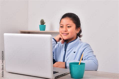 Niña latina estudiando en casa Stock Photo Adobe Stock