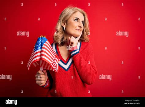Middle Age Blonde Patriotic Woman Holding United States Flags Celebrating Independence Day