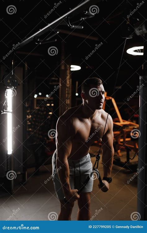 Guy Bodybuilder Model With A Naked Torso Trains In The Gym The Muscles Are Tense Dark
