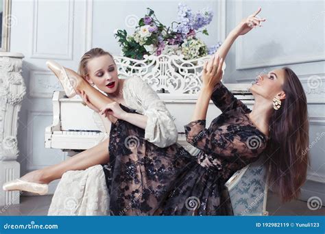 Joven Y Bonita Bailarina De Ballet De Brunette En El Piano Con Mujer Rubia En El Lujoso Estilo