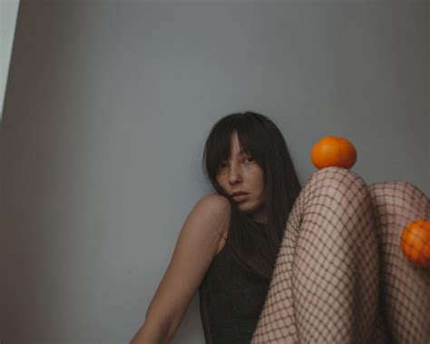 Premium Photo Sad Woman In Black Lingerie Ant Fishnettights With Mandarins