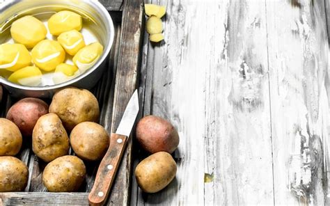 Patatas Peladas En Una Cacerola Con Patatas Sin Pelar En Bandeja Con Un