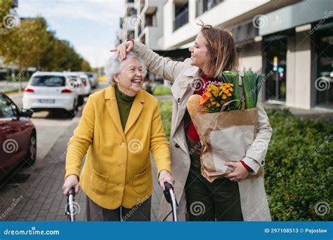 Mature Granddaughter Carrying Grandmother X27 S Shopping Bag Senior Woman And Caregiver Going