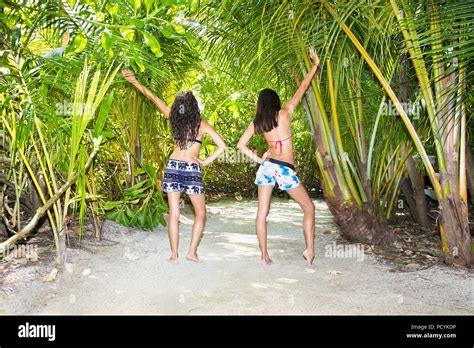 Zwei Mädchen im Bikini Berühren Hände mit Dschungel Blätter auf den Malediven Insel