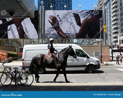 Intersection in Toronto with Large Street Poster and Mounted Police Man ...