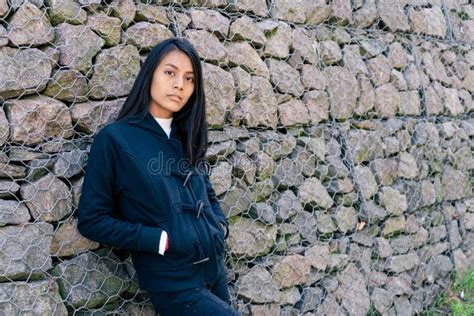 Retrato De Una Bella Joven Latina De Pelo Negro Y Ropa Casual Apoyada Sobre Un Fondo De Pared De