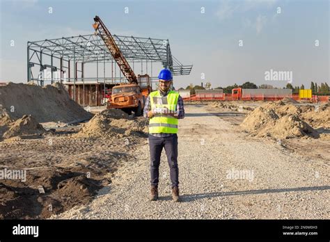 Engineer With Helmet And Vest Operating With Drone By Remote Control