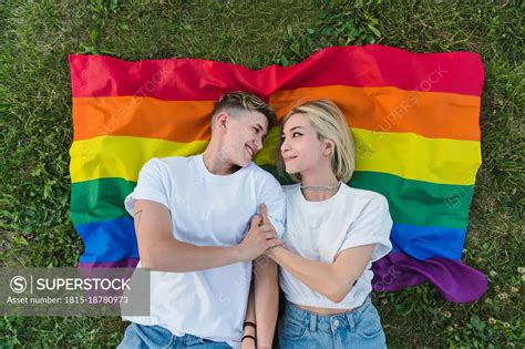 Lesbian Couple Holding Hands On Rainbow Flag SuperStock