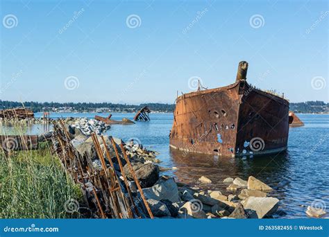 Old Wrecked Ship In The Water Rusting Away With Old Wooden Pillars In Front Stock Image Image