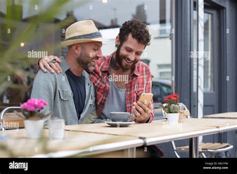 Couple Gay Assis Dans Le Caf T L Phone Partage Photo Stock Alamy