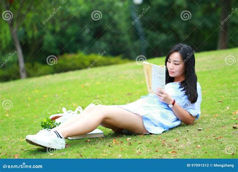 Fille Chinoise Lisant Le Livre Belle Jeune Femme Blonde Avec Le Livre Se Trouvant Sur L Herbe