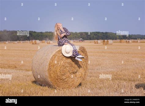 Une Jeune Fille Blonde Aux Cheveux Longs Dans Un Chapeau Blanc Se Repose Et Pose Pr S Des Gerbes
