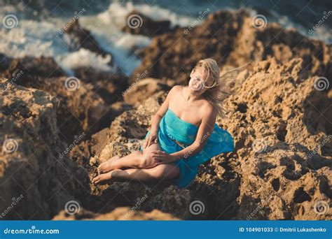 La Donna Bionda Seducente Di Signora Con Le Gambe Nude Sexy Mette E Arma L Uso Sulle Spalle Blu