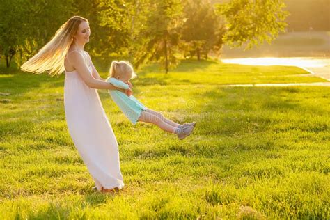 Petite Fille Blonde Mignonne Dans Une Robe Bleue Avec Une Belle Mère Aux Cheveux Longs Qui S